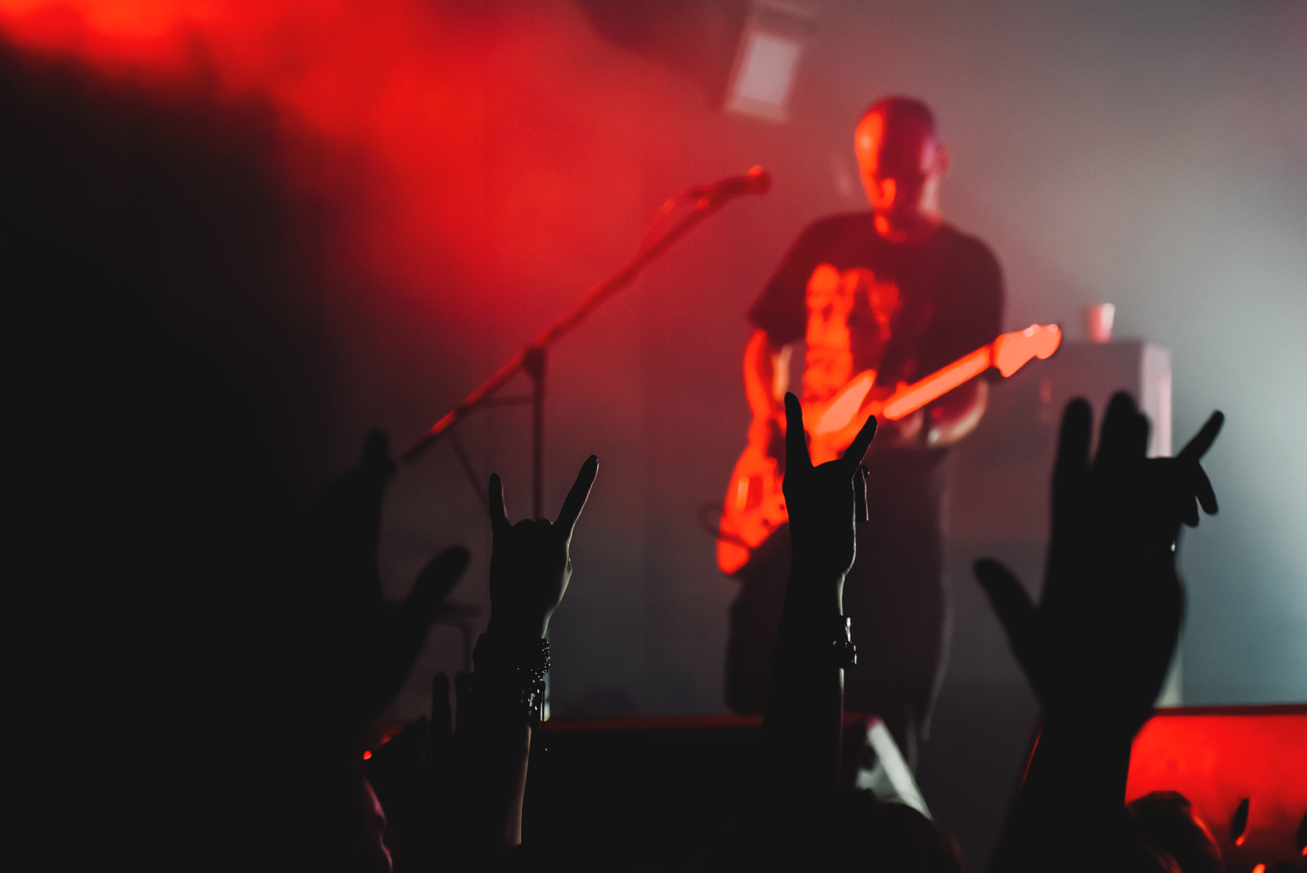 Live performer playing lead guitar in front of a crowd on a gig